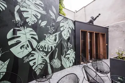 a mural on the side of a building with chairs at Maison Margo in Ghent