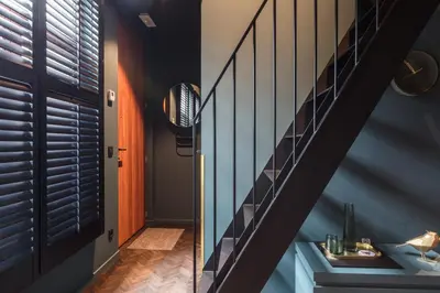 a hallway with a staircase and a blue wall at Maison Margo in Ghent