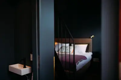 a bedroom with a bed with a mirror and a sink at Maison Margo in Ghent