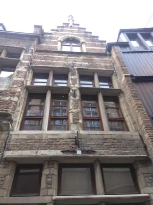 a tall brick building with windows on the side of it at Charming Suites Jan Zonder Vrees in Antwerp