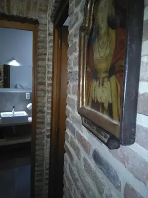 a painting of a woman hanging on a brick wall at Charming Suites Jan Zonder Vrees in Antwerp