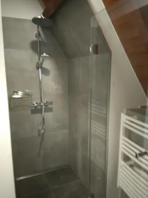 a shower with a glass door in a bathroom at Charming Suites Jan Zonder Vrees in Antwerp