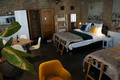 a bedroom with two beds and a table and chairs at Charming Suites Jan Zonder Vrees in Antwerp