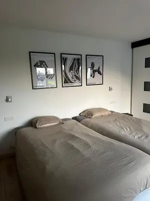 two beds in a bedroom with pictures on the wall at No reservat till 20 febrBeautiful rooms at countryside Brussel in Halle