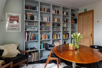 a room with a table and a book shelf with books at Studio Spiegelhof in Ghent