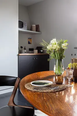 a wooden table with a vase of flowers on it at Studio Spiegelhof in Ghent