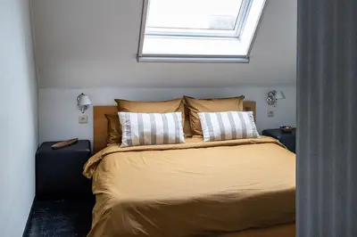 a bedroom with a bed with two pillows and a window at Studio Spiegelhof in Ghent