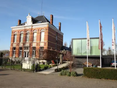 a large brick building with a fence in front of it at Art Of Dreams Deluxe 4 stars in Laakdal