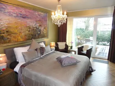 a bedroom with a large bed with a painting on the wall at Art Of Dreams Deluxe 4 stars in Laakdal