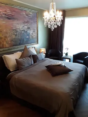 a bedroom with a large bed with a chandelier at Art Of Dreams Deluxe 4 stars in Laakdal