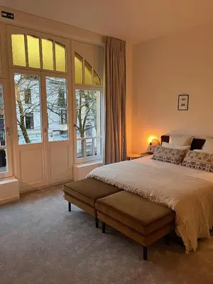 a bedroom with a bed and a large window at B&B Achilles in Ghent