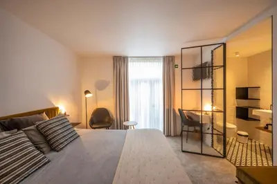 a bedroom with a large bed with a mirror and a desk at B&B Achilles in Ghent