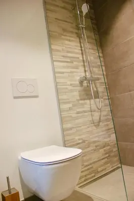 a bathroom with a shower with a toilet and a glass shower at Bennestay in Ghent
