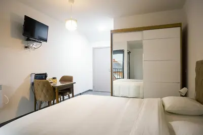 a bedroom with a bed and a desk with a television at Résidence la floraison in Brussels
