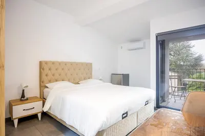 a bedroom with a large bed and a balcony at Résidence la floraison in Brussels