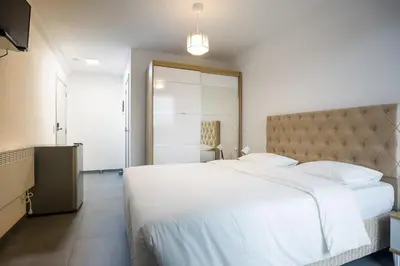 a bedroom with a large white bed with white sheets at Résidence la floraison in Brussels