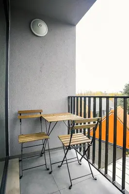 a balcony with a table and two chairs and a frisbee at Résidence la floraison in Brussels