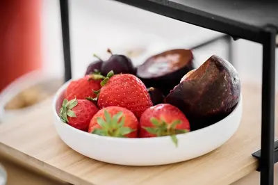 a bowl of strawberries and other vegetables on a counter at La Lys Rooms & Suites in Ghent