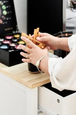 a woman holding wooden chopsticks on a counter at La Lys Rooms & Suites in Ghent