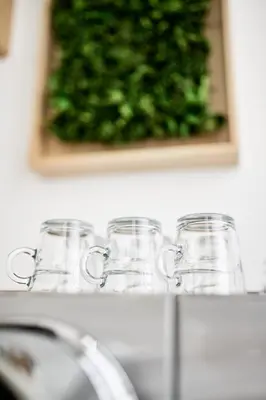 a row of glasses on a counter with a picture at La Lys Rooms & Suites in Ghent