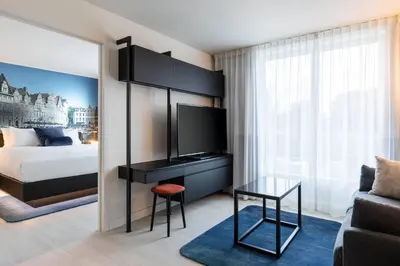 a bedroom with a bed and a tv and a table at Residence Inn by Marriott Ghent in Ghent