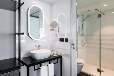a white bathroom with a sink and a shower at Residence Inn by Marriott Ghent in Ghent