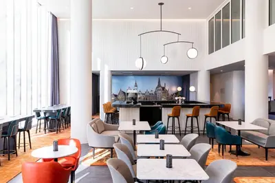 a restaurant with tables and chairs and a bar at Residence Inn by Marriott Ghent in Ghent