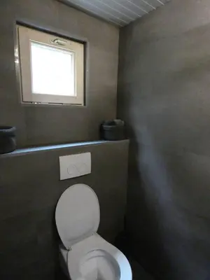 a bathroom with a white toilet with a window at Vakantiewoning De Kleine Duinberg - Chalet Nr 11 in Retie