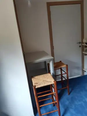 a desk and two chairs in a room with a door at Casa ENRICO in Antwerp