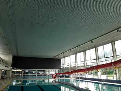 a large swimming pool in a building with windows at Casa ENRICO in Antwerp