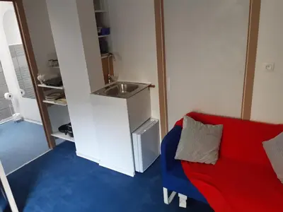 a living room with a red couch and a sink at Casa ENRICO in Antwerp
