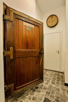 a large wooden door in a room with a clock on the wall at Fish Market B&B in Brussels