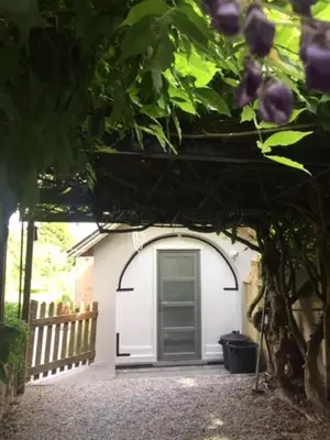 a small white garage with a door in it at Le Buis in Genval