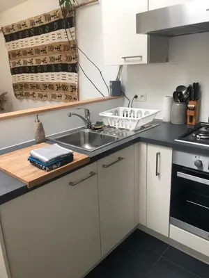 a kitchen with white cabinets and a sink at Le Buis in Genval