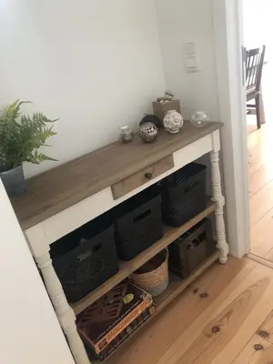 a console table in a living room with shelves at Le Buis in Genval