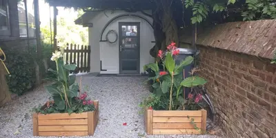 two plants in wooden boxes in front of a door at Le Buis in Genval
