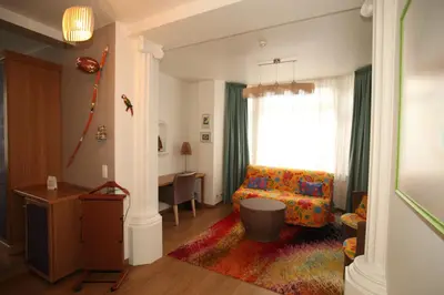 a living room with a couch and a window at Hotel La Roseraie in Wemmel