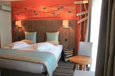 a bedroom with a large bed and a table at Hotel La Roseraie in Wemmel
