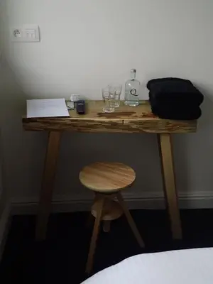 a wooden desk with a stool and a glass at Quarante Cinq in Evergem