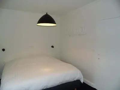 a bedroom with a white bed and a lamp at Quarante Cinq in Evergem