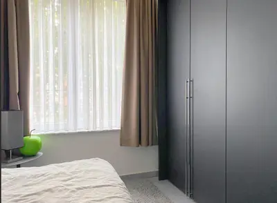 a bedroom with a closet and a bed and a window at Quartier des Quais Dansaert in Brussels