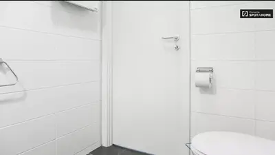a white bathroom with a toilet and a shower at Quartier des Quais Dansaert in Brussels
