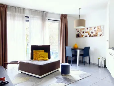 a living room with a couch and a dining room table at Quartier des Quais Dansaert in Brussels
