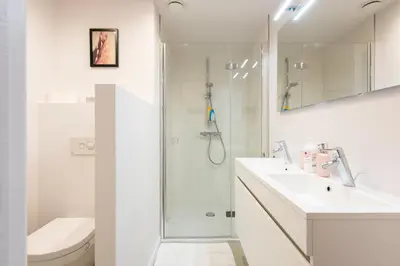 a bathroom with a shower and a sink and a toilet at Salt & Pepper Ghent in Ghent