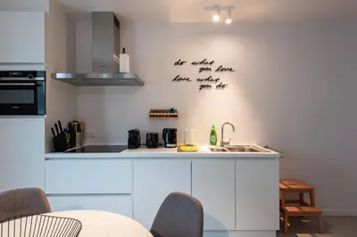 a kitchen with white cabinets and a sink at Salt & Pepper Ghent in Ghent
