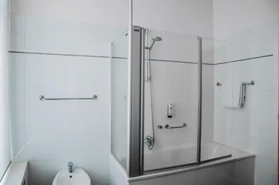 a shower with a glass door in a bathroom at Hotel Les Eleveurs in Halle