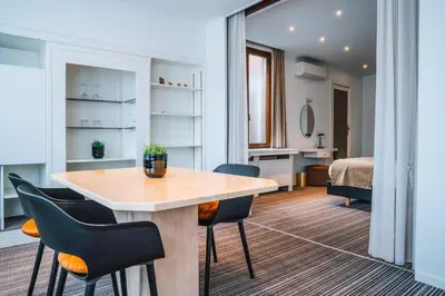 a room with a table and chairs and a bed at Hotel Les Eleveurs in Halle