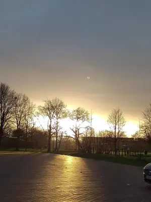 an empty parking lot with a sunset in the background at Villa Blanco in Opwijk