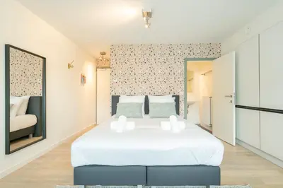 a bedroom with a large white bed in a room at SHWAY - The Card Room Green Studio in Antwerp