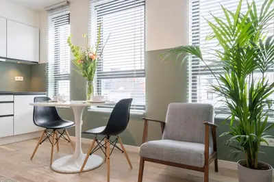 a kitchen with a table and chairs and plants at SHWAY - The Card Room Green Studio in Antwerp